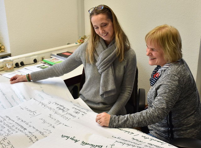 Kolleginnen werten Workshopergebnisse am gemeinsamen Besprechungstisch aus.