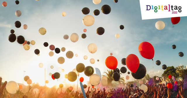 Menschen lassen bunte Luftballons in den Himmel aufsteigen.