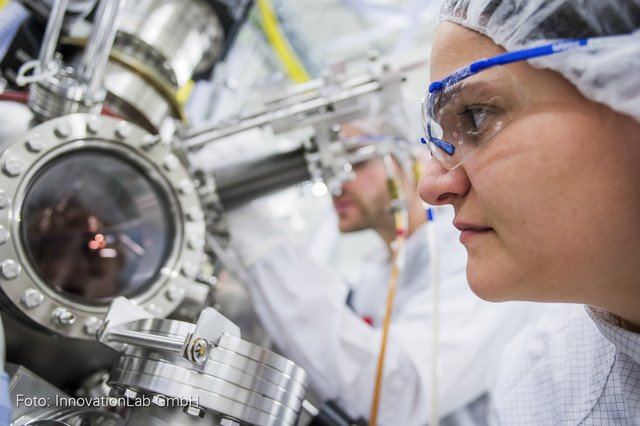 Junge Forscherin beobachtet ein wissenschaftliches Untersuchungsgerät.