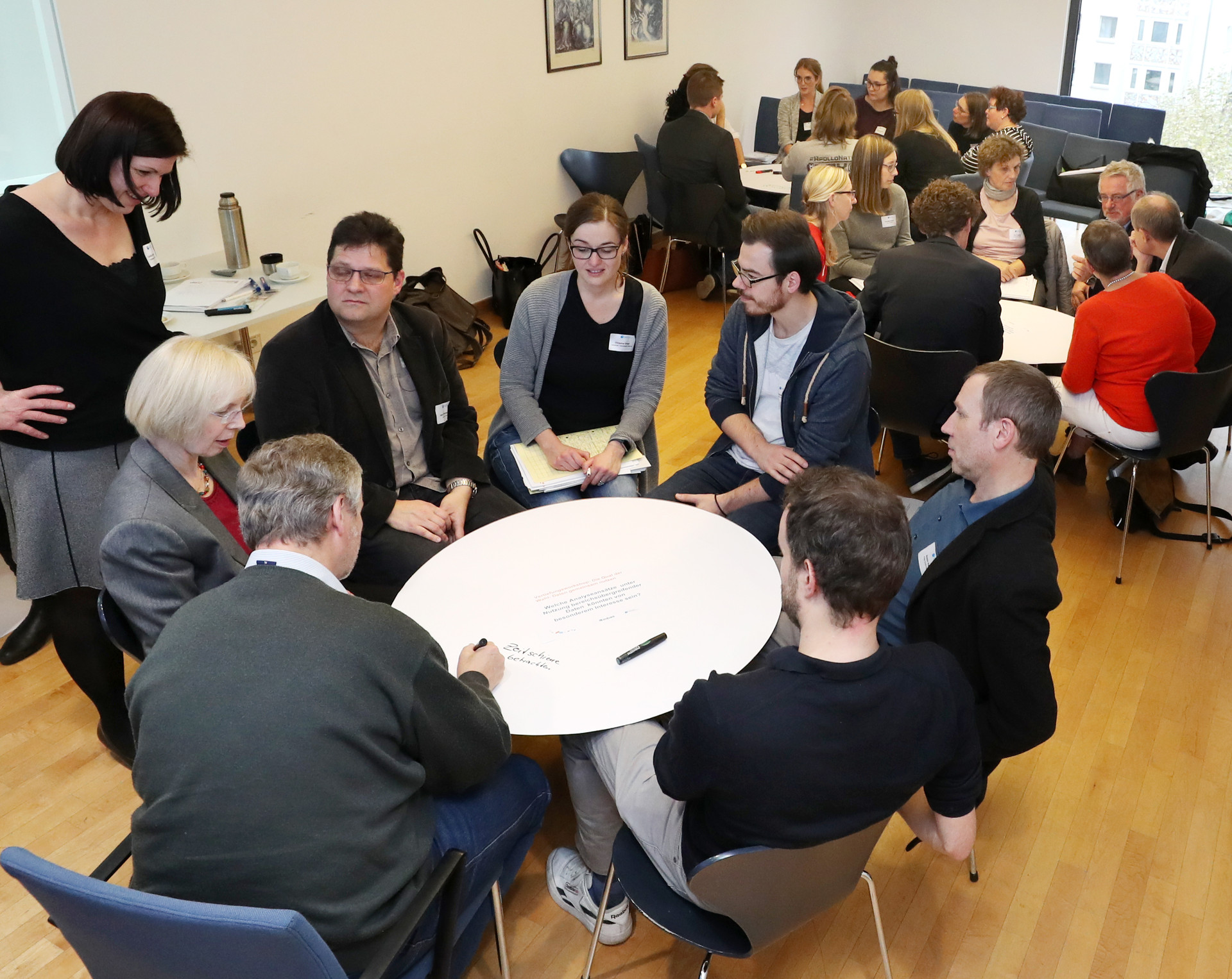 Gruppenbild mit drei Arbeitsgruppen an runden Pappscheiben