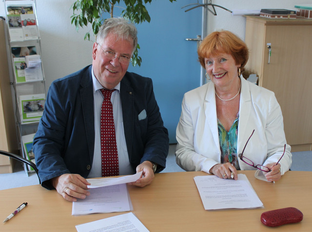 Kreisbeigeordneter Dr. Michael Reuter MdL a. D. (l.) und Felicitas von Küchler, Leiterin Transferagentur Hessen (r.), unterzeichnen die Zielvereinbarung.