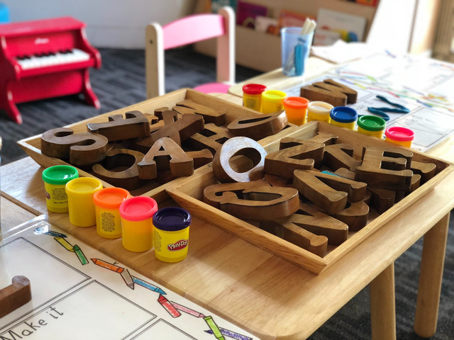 Kindertisch mit Holzlettern und bunten Malutensilien
