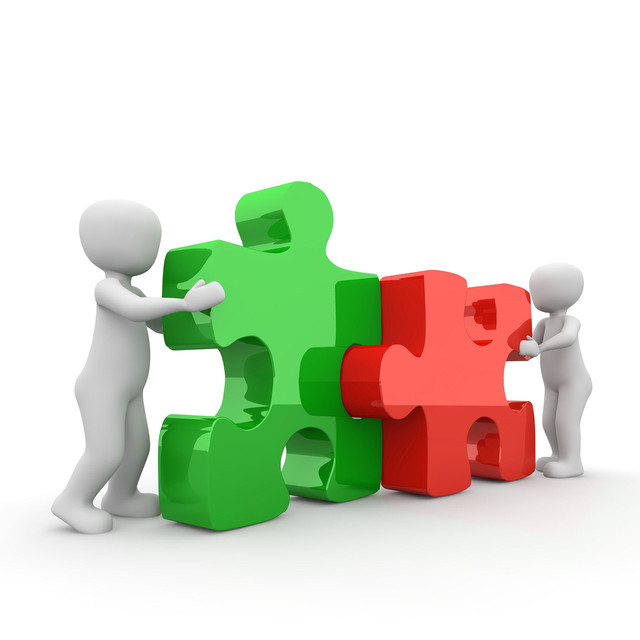 Zwei Menschen setzen ein Puzzle zusammen.