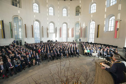 Geladene Gäste verfolgen das Grußwort des Frankfurter Oberbürgermeisters.